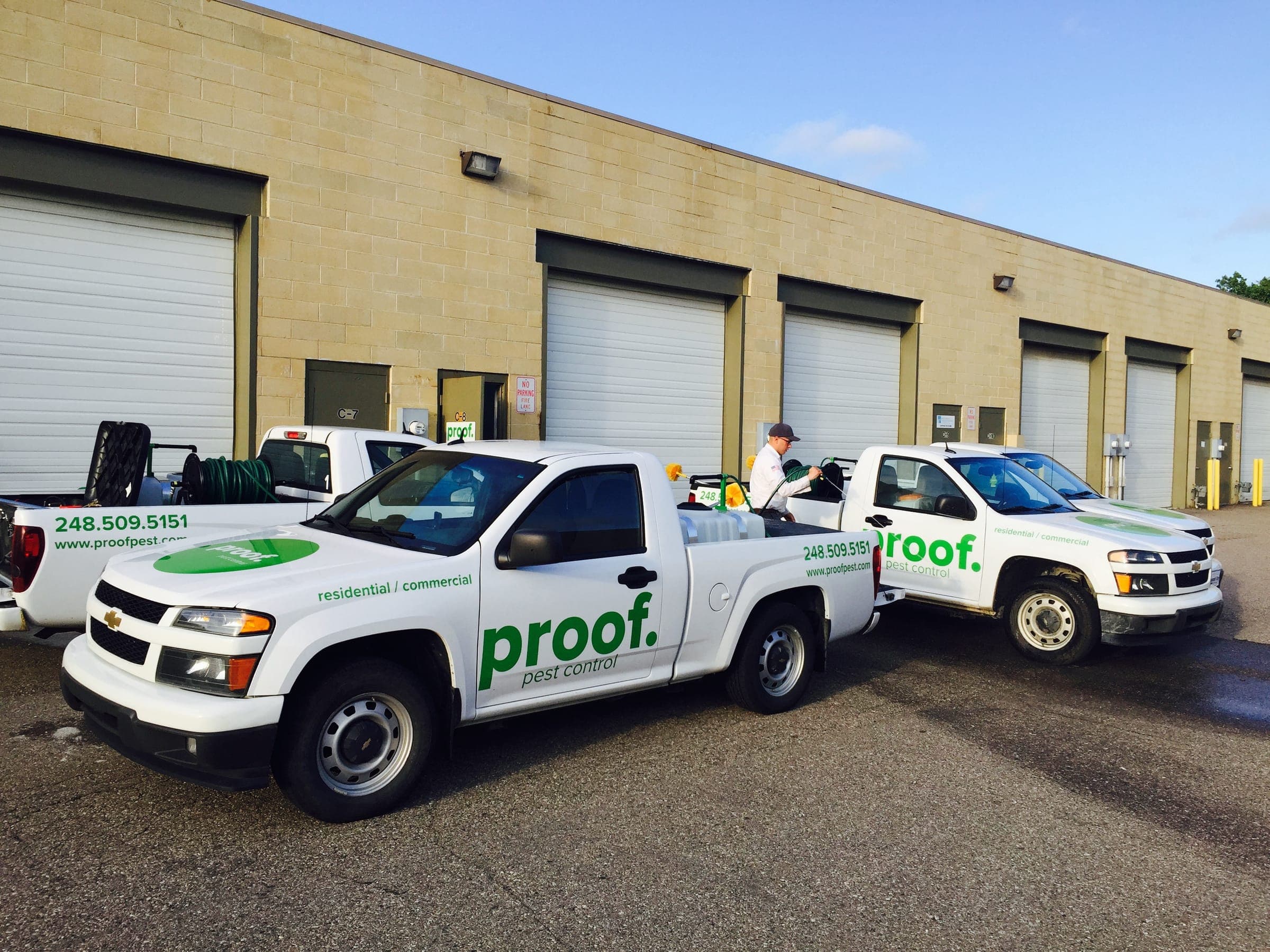 A row of branded Proof Pest Control trucks
