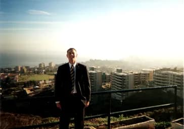 Young Allan Draper in a suit overlooking a Chilean coastal city